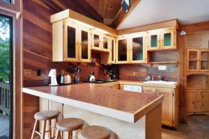 a kitchen with wooden cabinets and a counter with stools at Rustic River Paradise - 1 Bed 2 Bath Vacation home in Baring in Baring