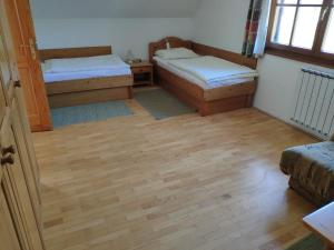 een kamer met 2 bedden en een houten vloer bij Antela, 142 m2 appartment for 12 person in Mariborsko Pohorje in Hočko Pohorje