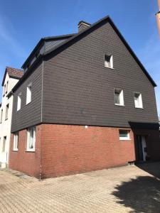 een rood bakstenen gebouw met een zwart dak bij Ferienwohnung Götel in Gladbeck