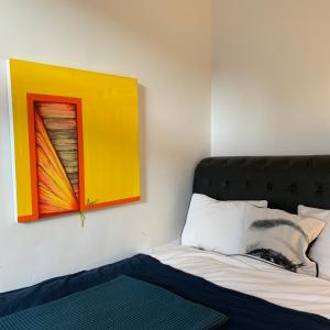 1 dormitorio con 1 cama y una pintura en la pared en Nillah, en Oslo