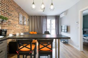 una cucina con un grande tavolo nero con sedie di Orange, modern apartment in the city centre a Cracovia