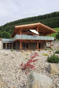 ein großes Haus mit Balkon auf einem felsigen Hof in der Unterkunft Mountain Chalet R in Berwang