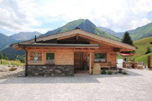 ein kleines Blockhaus mit Bergen im Hintergrund in der Unterkunft Mountain Chalet R in Berwang