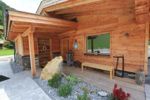 eine Holzhütte mit einer Bank auf einem Deck in der Unterkunft Mountain Chalet R in Berwang