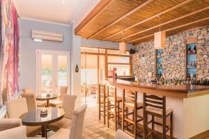 eine Bar in einem Restaurant mit Tischen und Stühlen in der Unterkunft Virginia Hotel in Samos