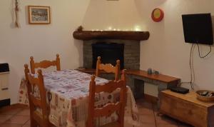 a dining room with a table and a fireplace at Casetta con camino in La Magdeleine
