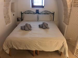 um quarto com uma cama com duas toalhas em I PapaTrulli Resort - I Trulli della NaturaBio em Martina Franca