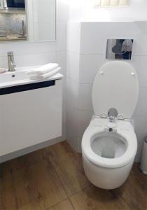 een witte badkamer met een toilet en een wastafel bij Art Apartments w centrum Krakowa (Śródmieście, Stradom) in Krakau