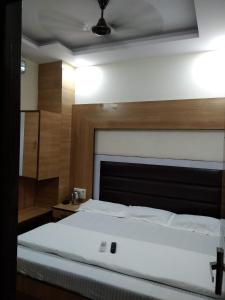 a bedroom with a large white bed with a wooden headboard at Silver Palace Hotel in New Delhi