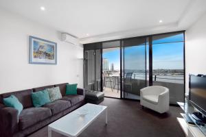 a living room with a couch and a tv at Docklands Private Collection - NEWQUAY in Melbourne