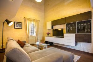 a living room with a couch and a tv at THE LOFT in Żabbar