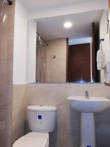 La salle de bains est pourvue de toilettes blanches et d'un lavabo. dans l'établissement Hotel Posada de Santa Elena, à Tunja