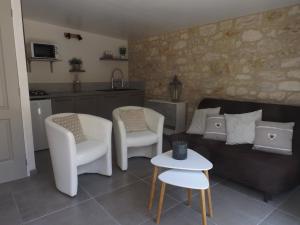 a living room with a couch and chairs and a table at Gite les bois 2 in Gignac