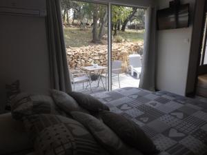 a bedroom with a bed and a view of a patio at Gite les bois 2 in Gignac