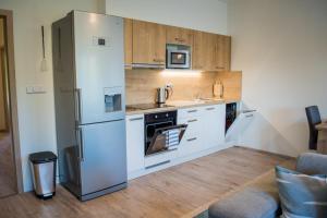 uma cozinha com um frigorífico de aço inoxidável e armários de madeira em Apartmán Laura, Frymburk em Frymburk