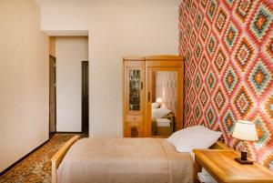 a bedroom with a bed and a table and a wall at Brick walls in Gori