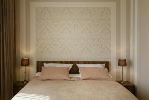 a bedroom with a large bed with two lamps at Brick walls in Gori