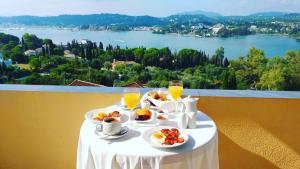 una mesa con platos de comida y vasos de zumo de naranja en Elite Corfu - Adults Friendly, en Kommeno