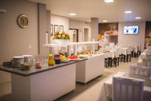 a buffet line in a restaurant with plates of food at Hotel Iomere in Iomerê