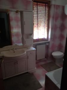 a bathroom with a sink and a toilet and windows at Alloggio turistico La nuova Velzna in Bolsena