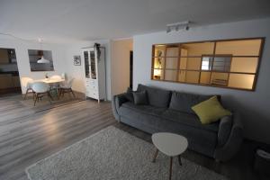 ein Wohnzimmer mit einem grauen Sofa und einem Tisch in der Unterkunft Apartment Heddesheim in Heddesheim