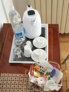 a table with a tea kettle and plates and a bottle of water at La Casa in Piazza in Gubbio