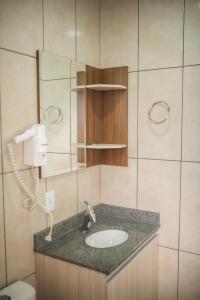 a bathroom with a sink and a mirror at Hotel Iomere in Iomerê