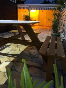 a picnic table and benches on a stone patio at La petite bourgeoise in Petit-Bourg