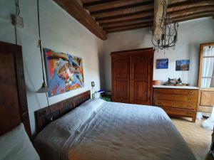 a bedroom with a large bed and a dresser at La Casa Di Dina in Castelmuzio