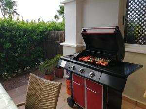 a grill with hot dogs on it in a backyard at Casa Bella Murcia in Roldán