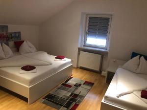 a small room with two beds and a window at Center Rooms Villach in Villach
