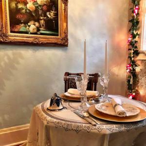 una mesa con mantel y velas en The Lancaster Manor Bed and Breakfast en Gainesville