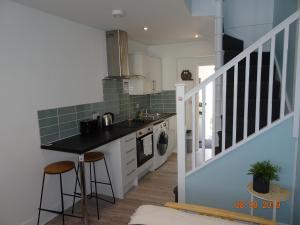a kitchen with a sink and a counter with stools at The Whiteways in Bristol