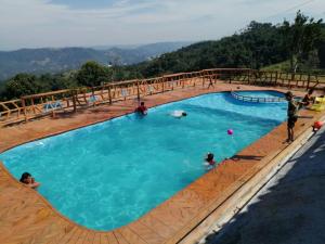 una gran piscina con gente jugando en ella en Finca campestre y recreativa los potrillos, en Doradal
