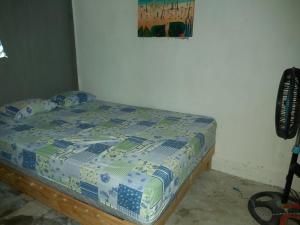 a bedroom with a bed with a comforter on it at Delmar Hostal in Bacalar