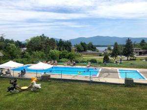 a large swimming pool with people in a park at Hill View Motel and Cottages in Lake George