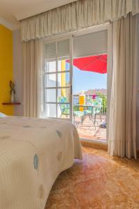 a bedroom with a bed and a patio with an umbrella at Alojamiento Colina del Sol in Torrox +99 photos