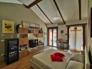 ein Wohnzimmer mit einem Bett, einem Sofa und einem TV in der Unterkunft Regis B&B Appartamenti centro storico in Chivasso