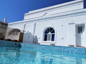 ein weißes Haus mit einem Pool davor in der Unterkunft Loukas Kontos Traditional House in Emporio