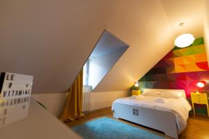 1 dormitorio con cama y pared geométrica en APPARTEMENT LE VITAMINE - topbnb dijon en Dijon