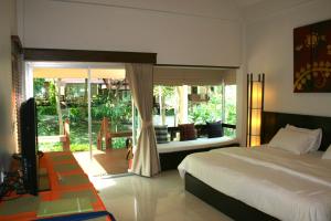 a bedroom with a bed and a view of a balcony at Palita Lodge - SHA Plus in Haad Rin