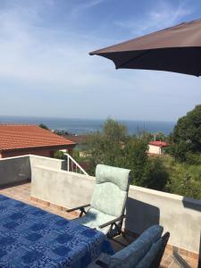 a patio with a chair and an umbrella at Villa Milka in Utjeha +26 photos
