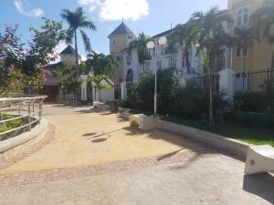 a row of houses with palm trees and a sidewalk at ROSI Ocean Sand Hotel Apt (@Sandcastles) in Ocho Rios