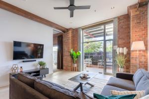uma sala de estar aberta com uma parede de tijolos em Luxury 3 brm 2 bath Woolstore apt with Courtyard em Brisbane