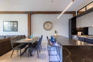 uma cozinha com mesa e cadeiras e um relógio na parede em Luxury 3 brm 2 bath Woolstore apt with Courtyard em Brisbane
