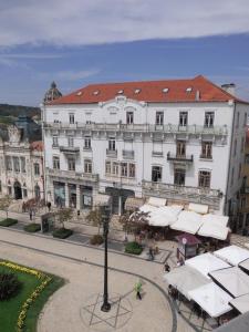 a large white building on a city street at Hotel Larbelo in Coimbra