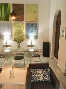uma sala de estar com um sofá, mesas e cadeiras em TYP Sevilla em Sevilha