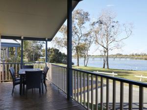a porch with a table and chairs and a view of the water at Stuarts Point Holiday Park in Stuarts Point