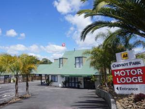 een motorlodge gebouw met een bord ervoor bij Cheviot Park Motor Lodge in Whangarei