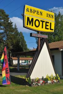 een bord voor een super herberg motel met een vlag bij Aspen Inn in Fort Klamath
